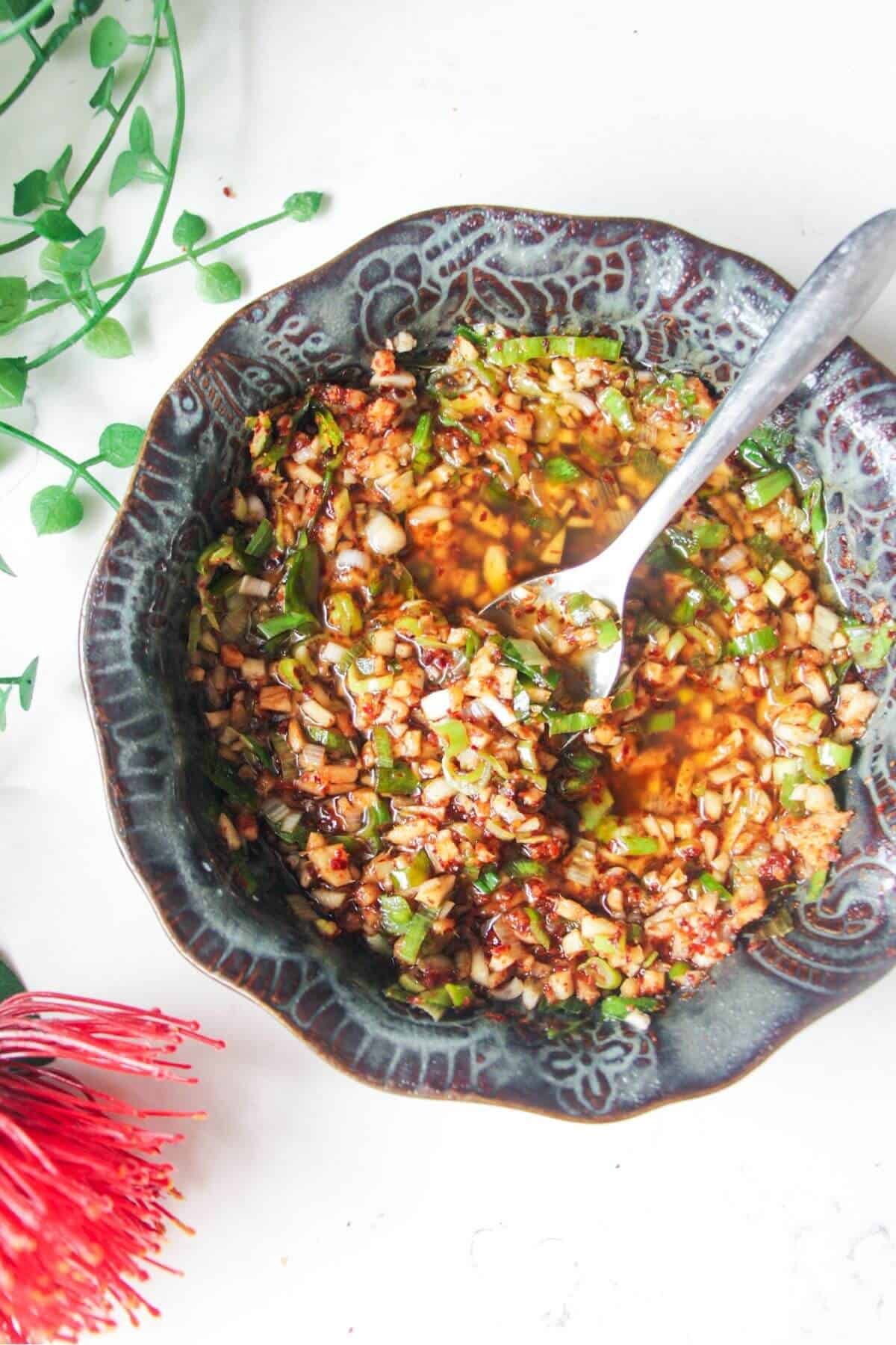 Sizzling oil in a small black patterned bowl.