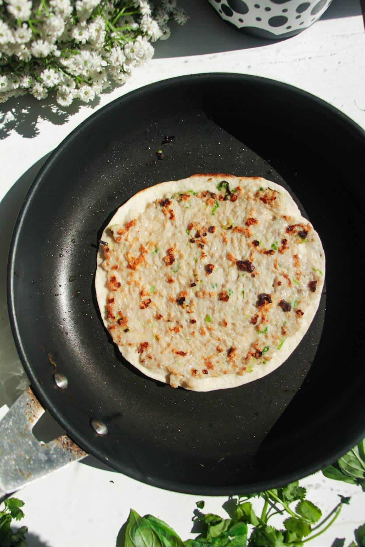 Bahn mi taco cooking in a small frying pan.