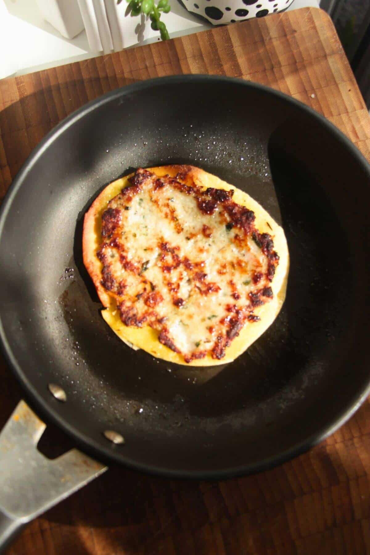 Sausage topped taco in a small pan.