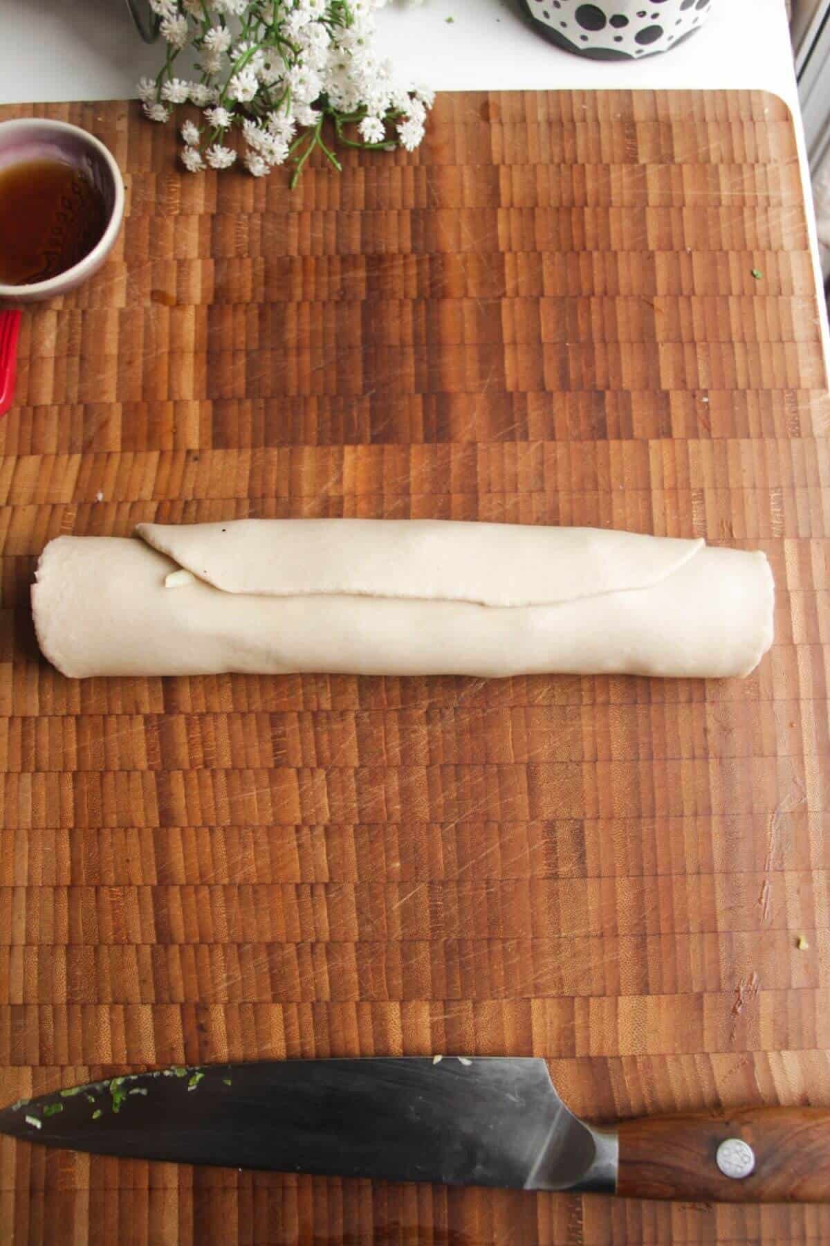 Dough log on a wooden board.