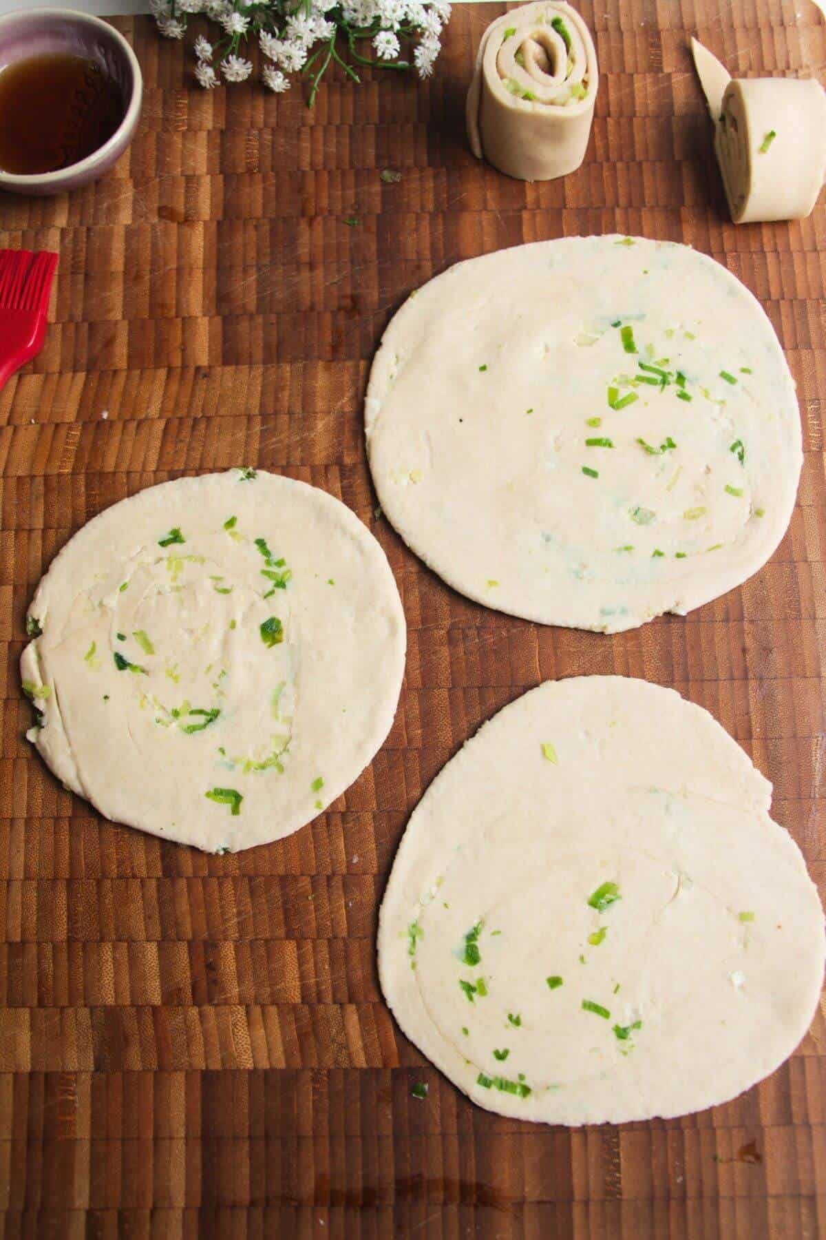 Three rolled out scallion pancakes.