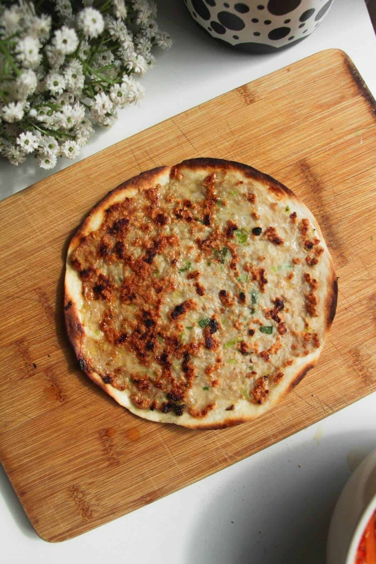 Cooked banh mi taco on a wooden board.