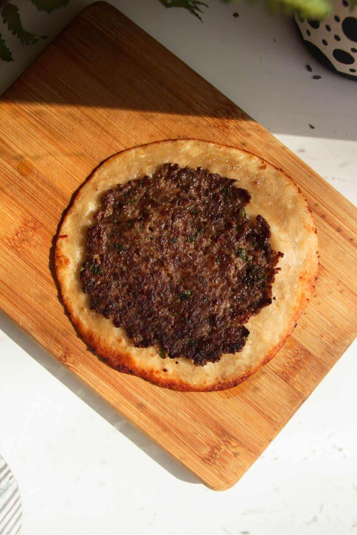 Cooked lamb on a mini tortilla.