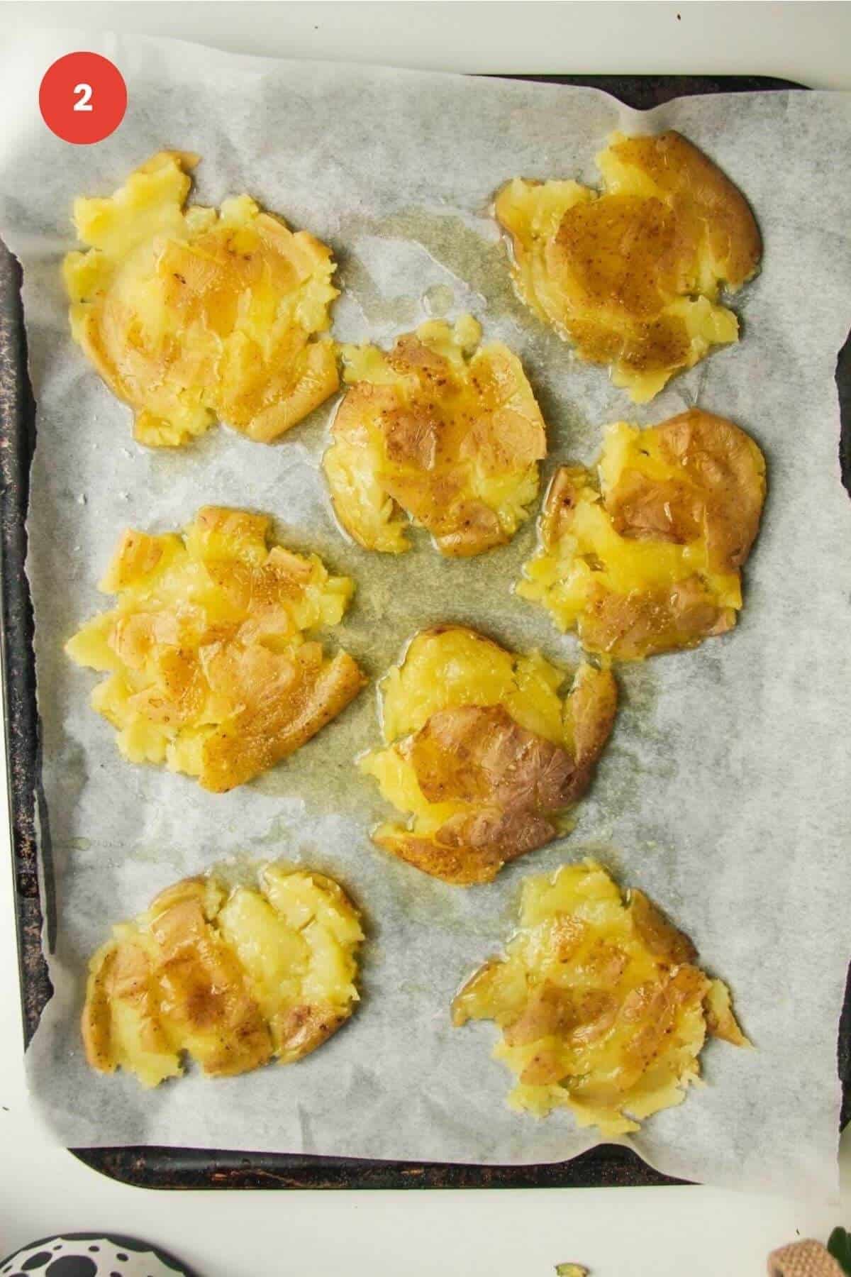 Potatoes smashed on a baking sheet.
