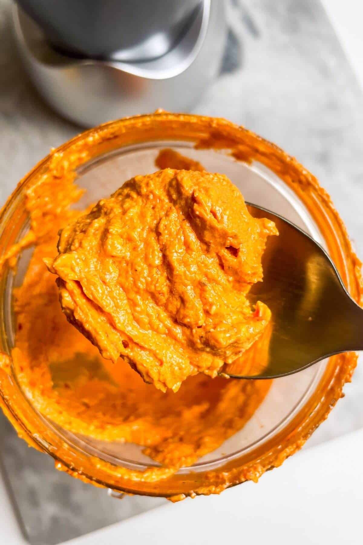 Spicy feta dip on a gold spoon.