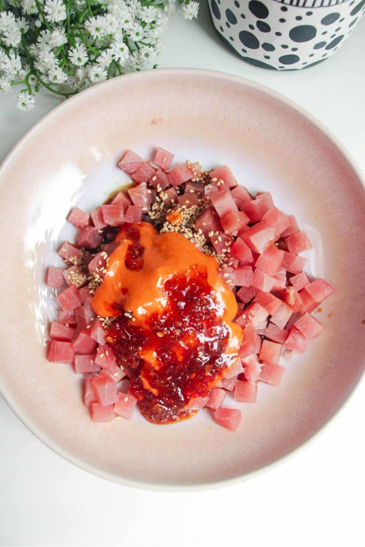 Diced tuna in a bowl with spicy mayo, sesame seeds and soy sauce.