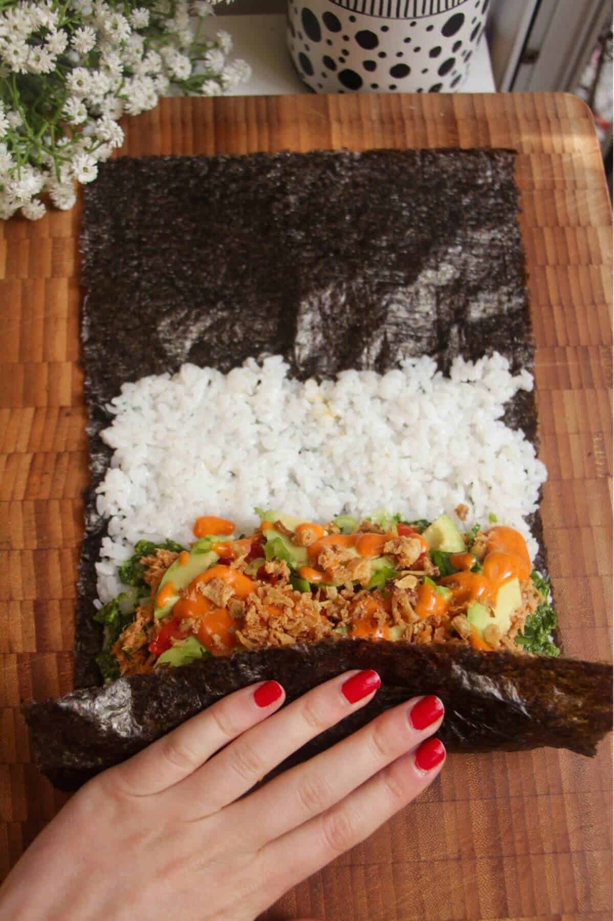 Hand rolling sushi burrito.