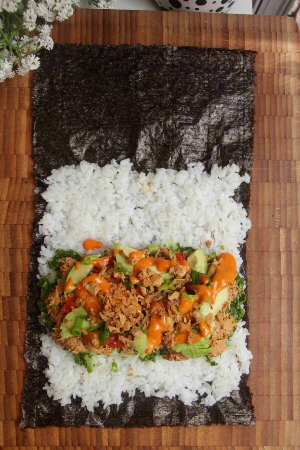 Nori sheet topped with sushi rice, tuna mix, avocado and spicy sauce.