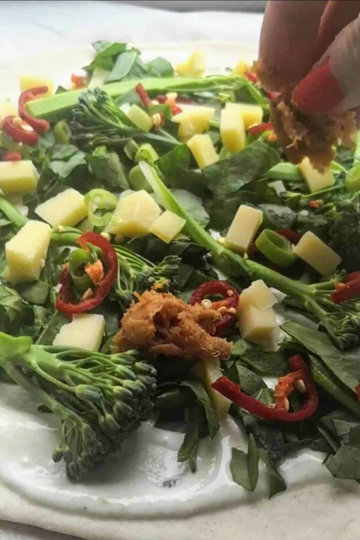 Close up of whipped ricotta pizza with sausage, chilli and broccolini.