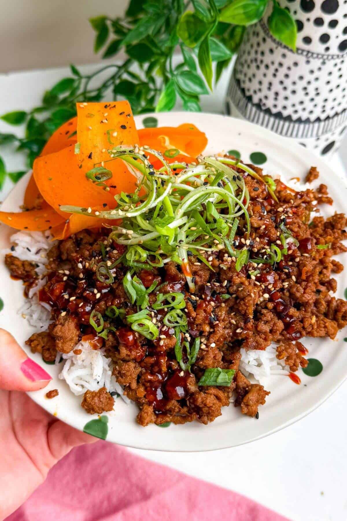 Holding sticky gochujang rice bowl.