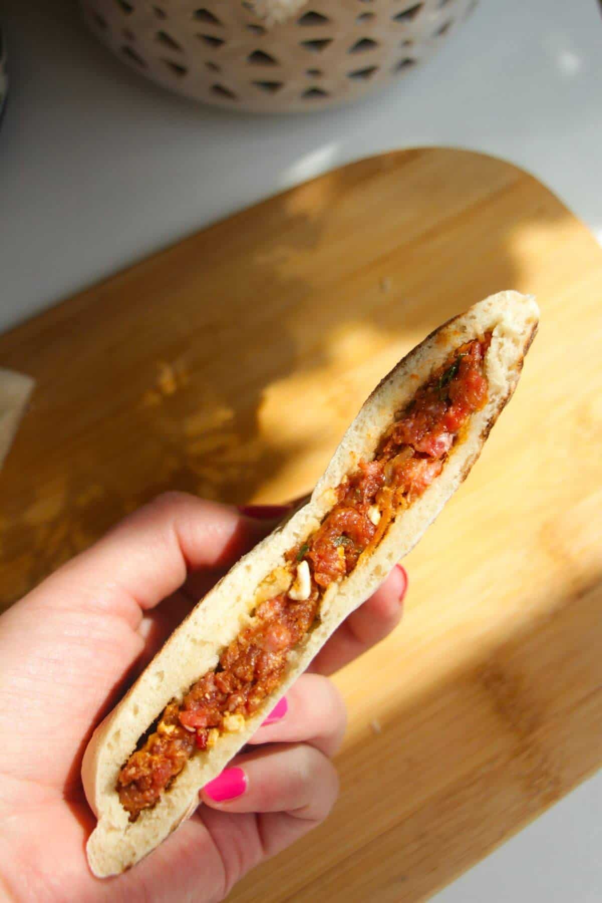Hand holding stuffed flatbread.