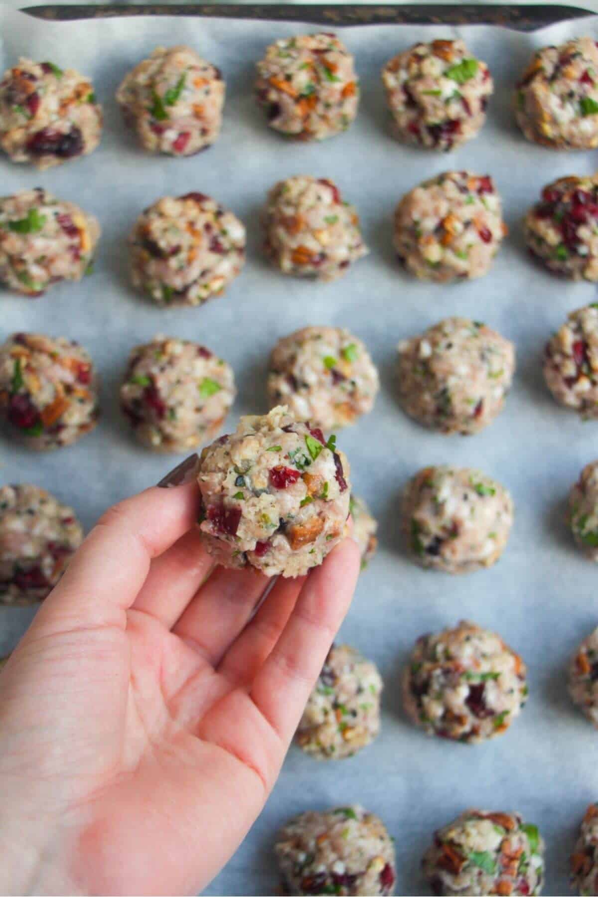 Hand holding a formed stuffing ball with more stuffing balls in the background.