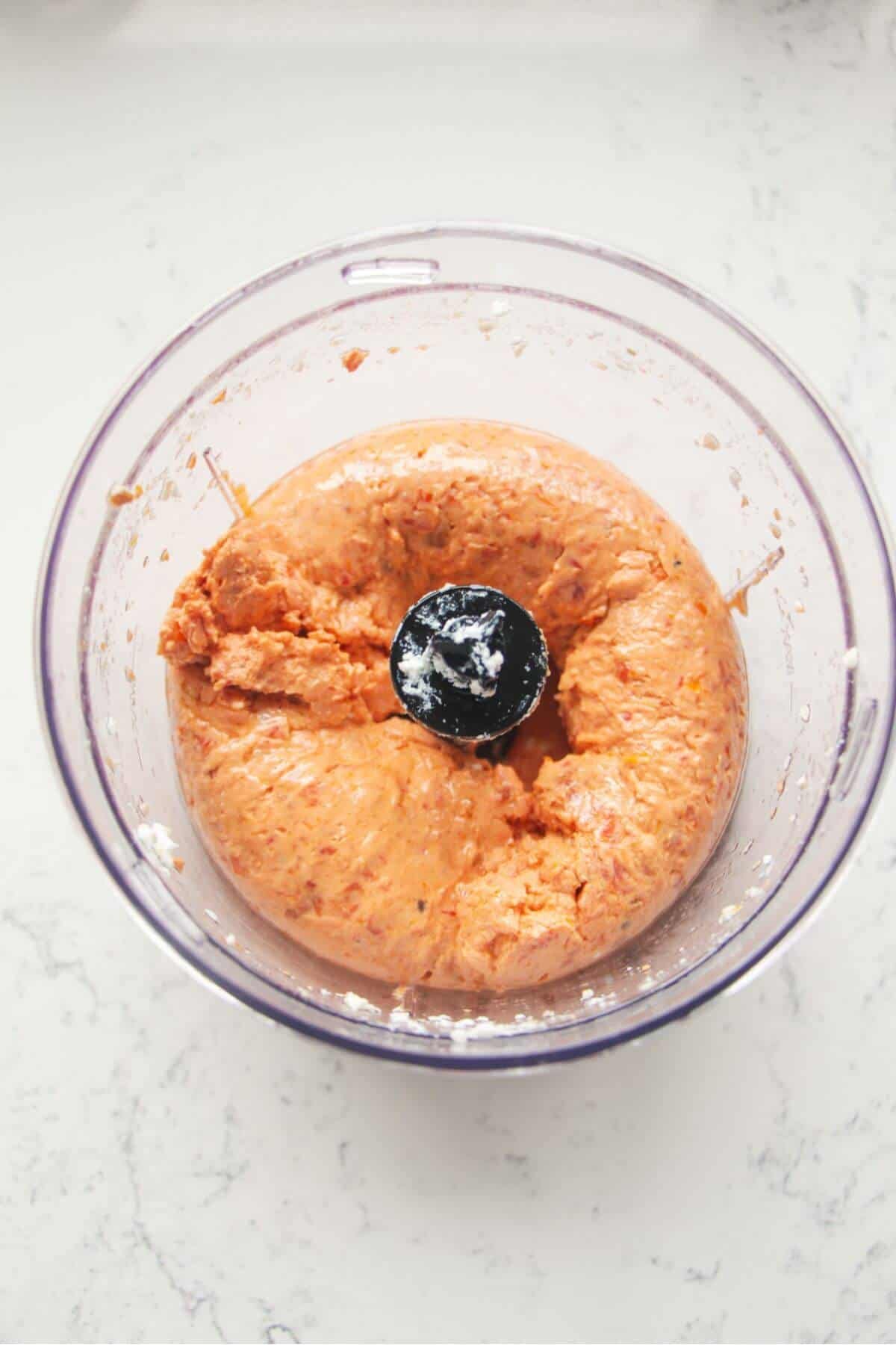 Blended sundried tomato feta dip in a small food chopper.