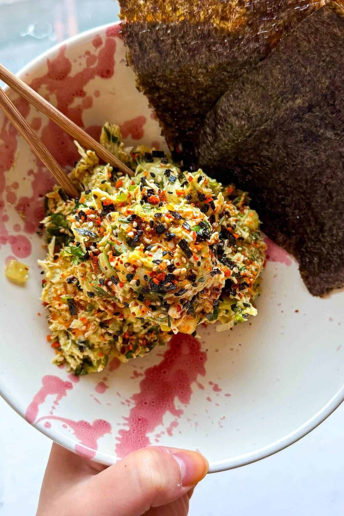 Chicken salad in a bowl with nori sheets on the side.