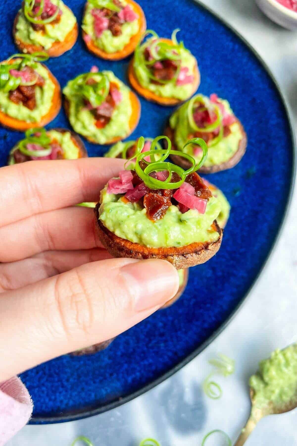 Holding loaded sweet potatoe bite.