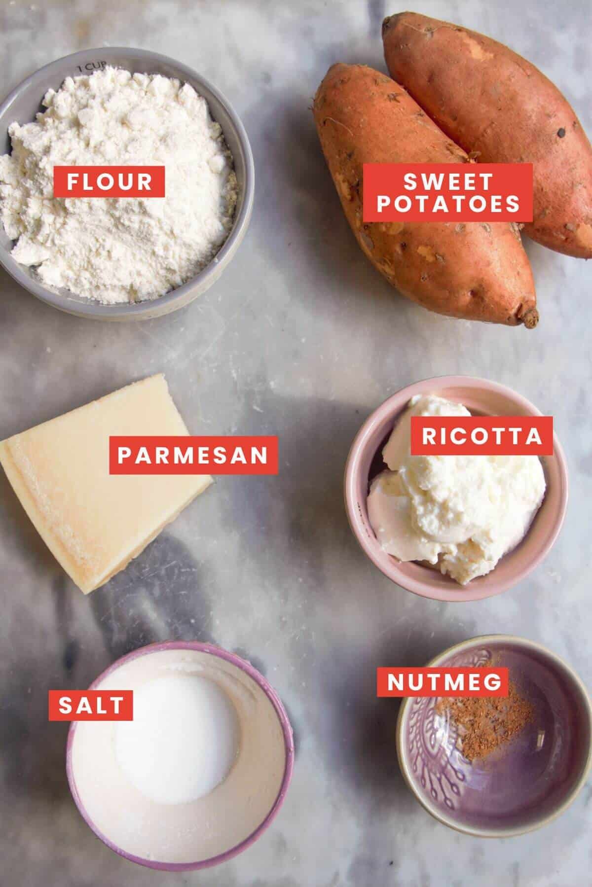 Ingredients for sweet potato gnocchi laid out on a grey marble background.