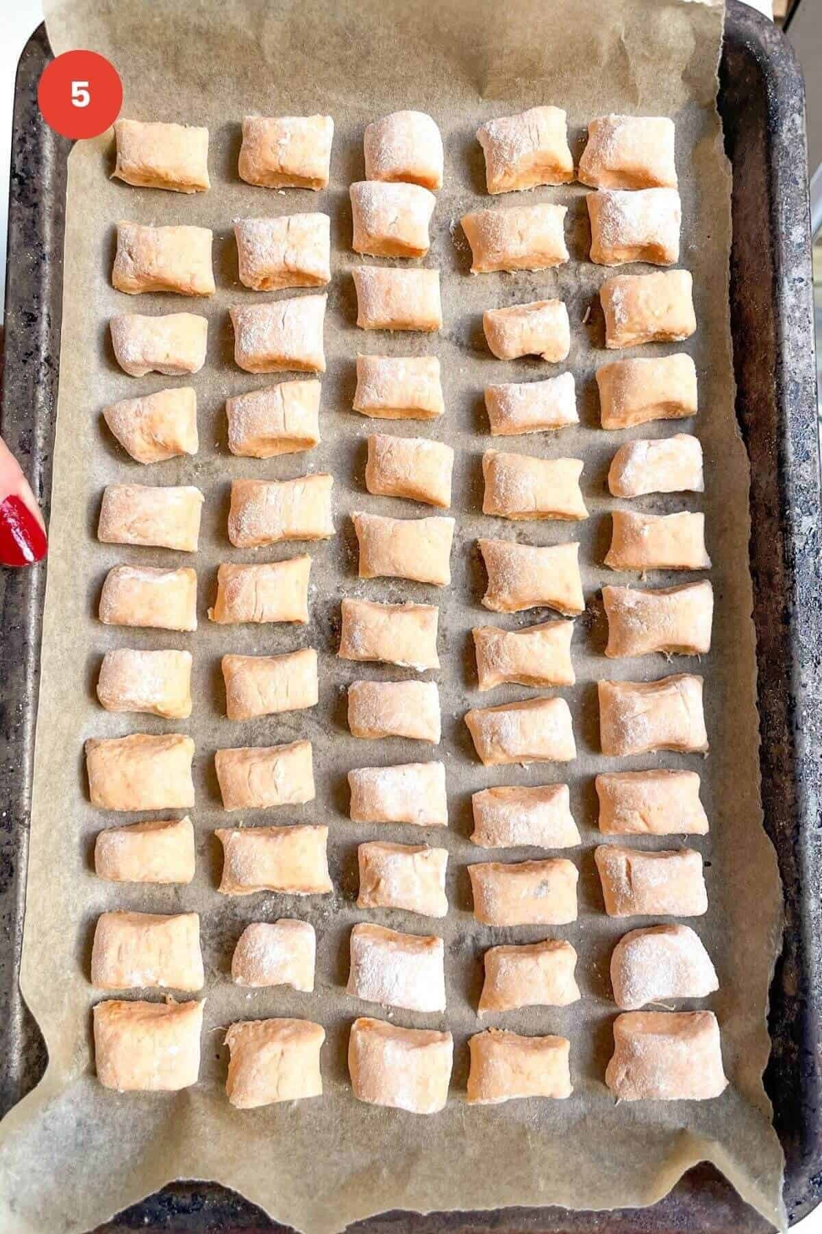 Sweet potato gnocchi on a lined tray.