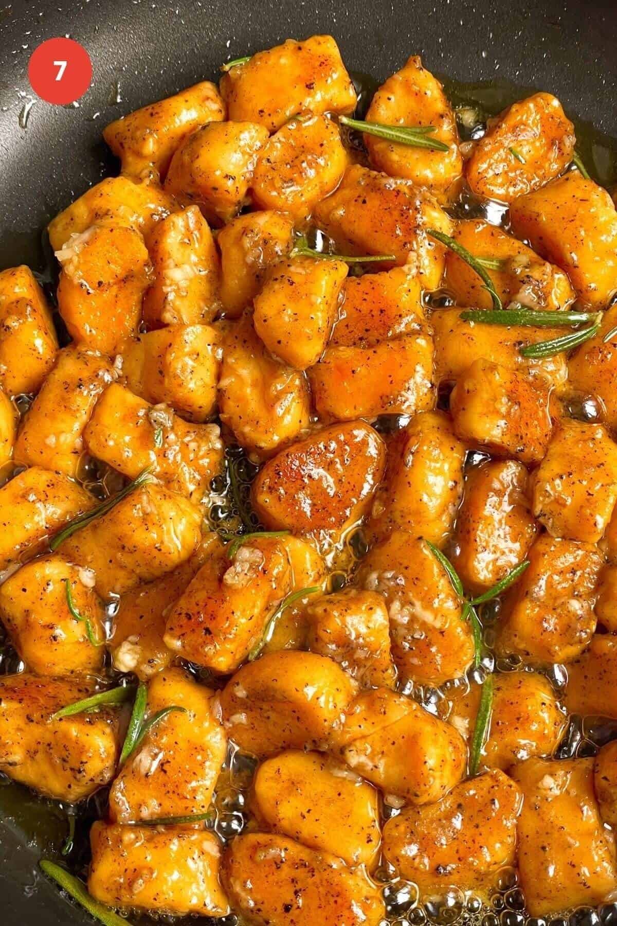 Sweet potato gnocchi in brown butter sauce in a pan.