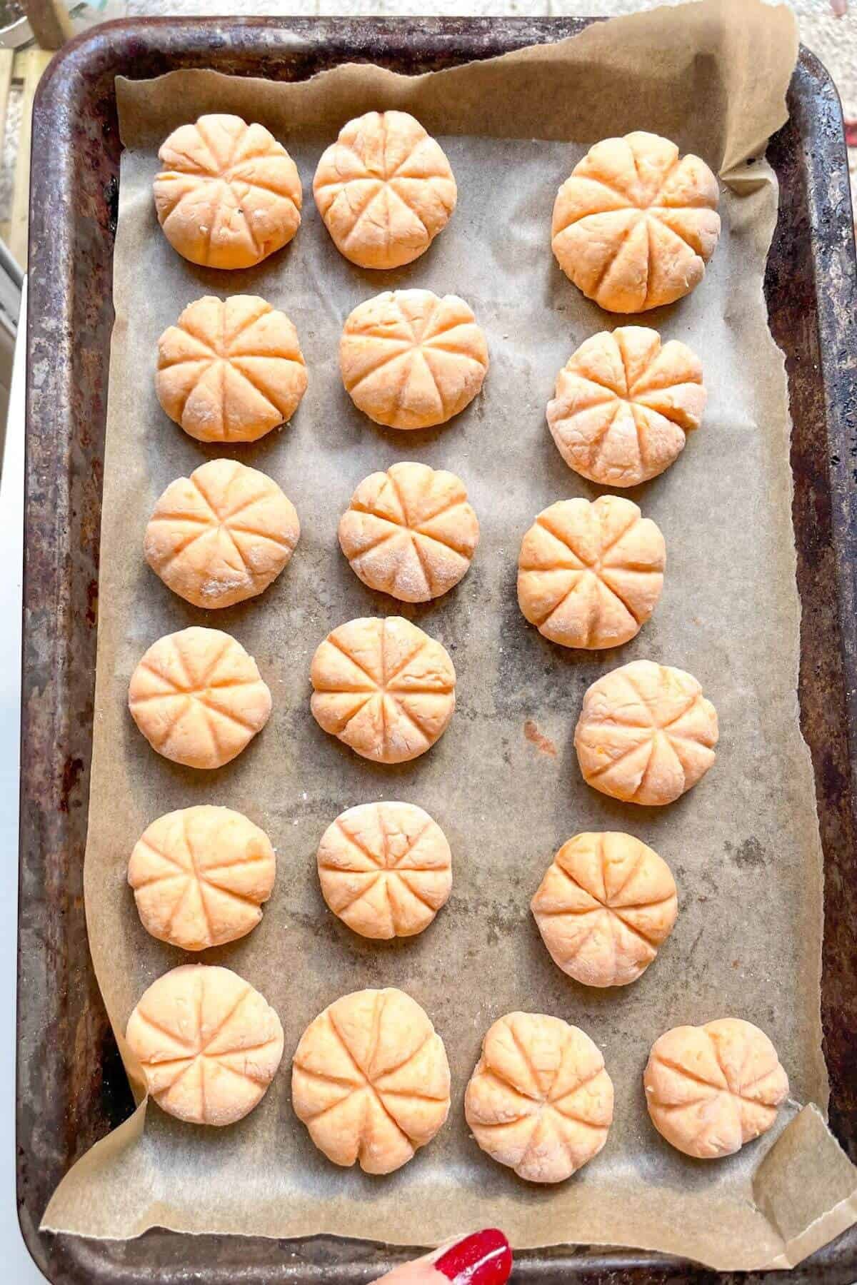 Pumpkin shaped gnocchi on a lined tray.