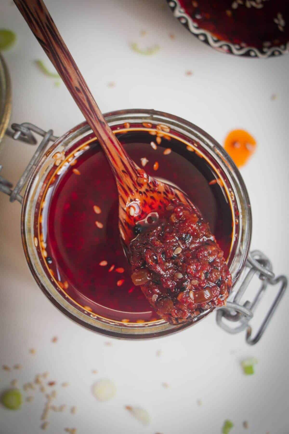 Wooden spoon in a jar of chilli oil.
