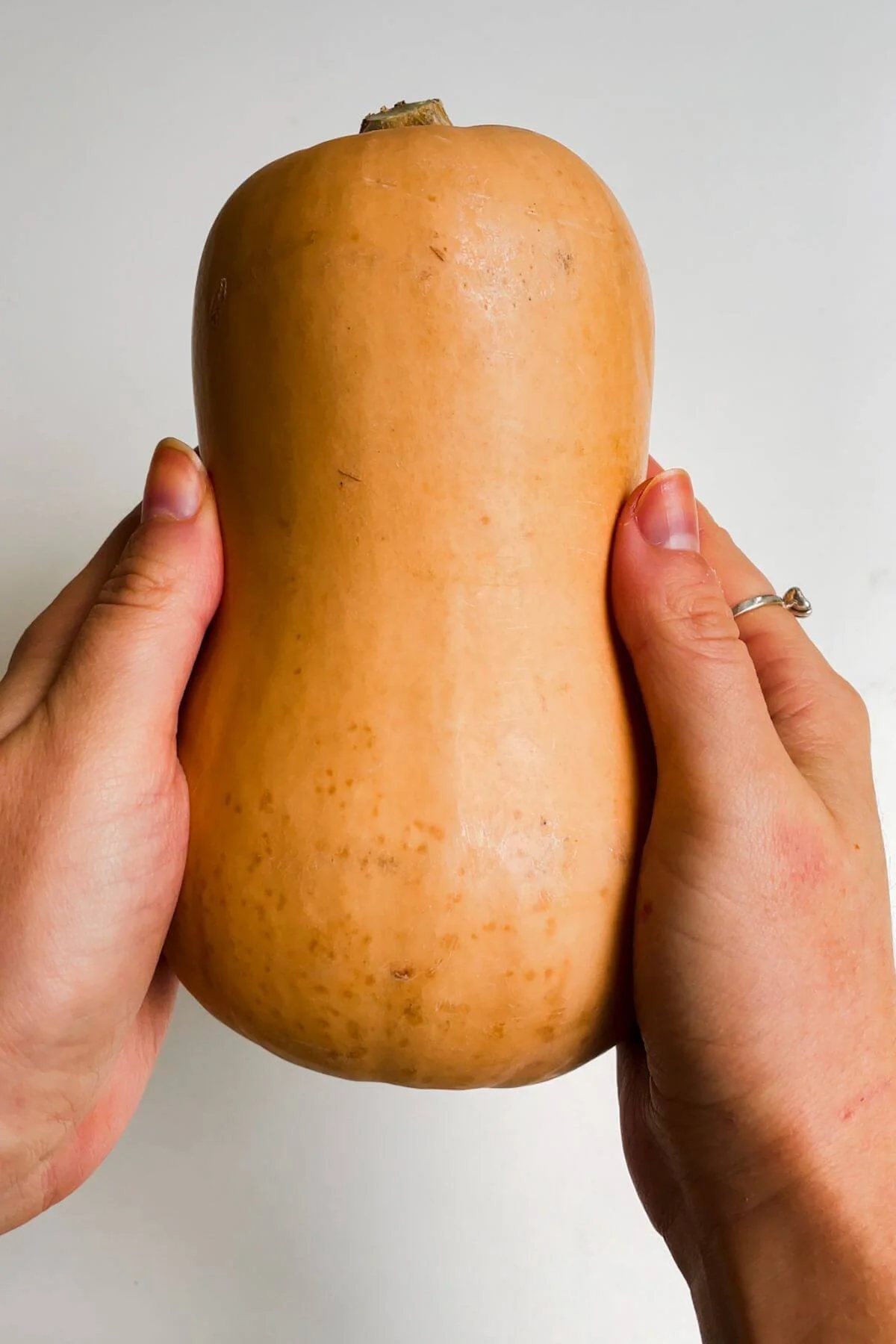 Holding squash with two hands.
