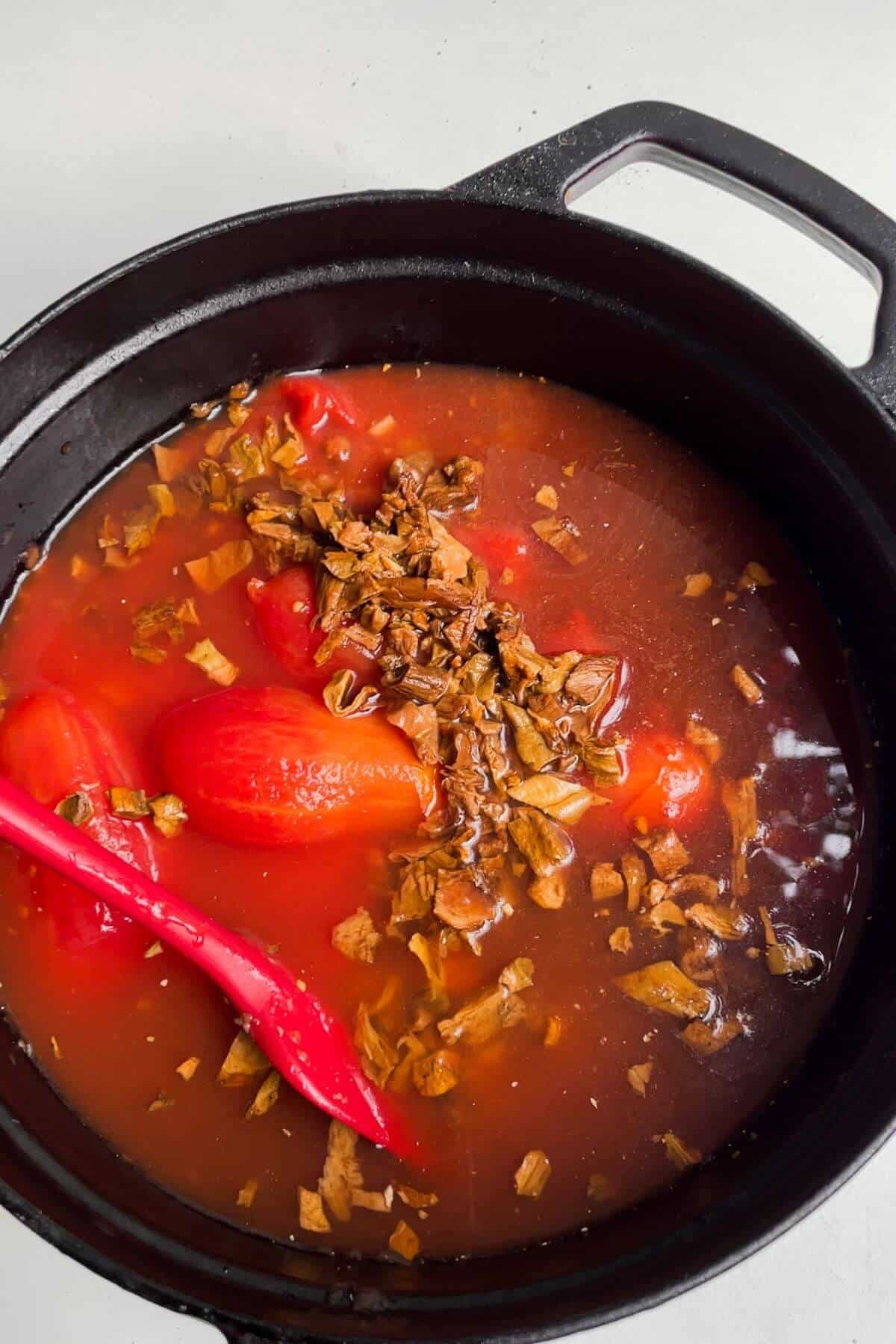 Tomatoes, beans, mushrooms and stock added to lasagna soup pot.