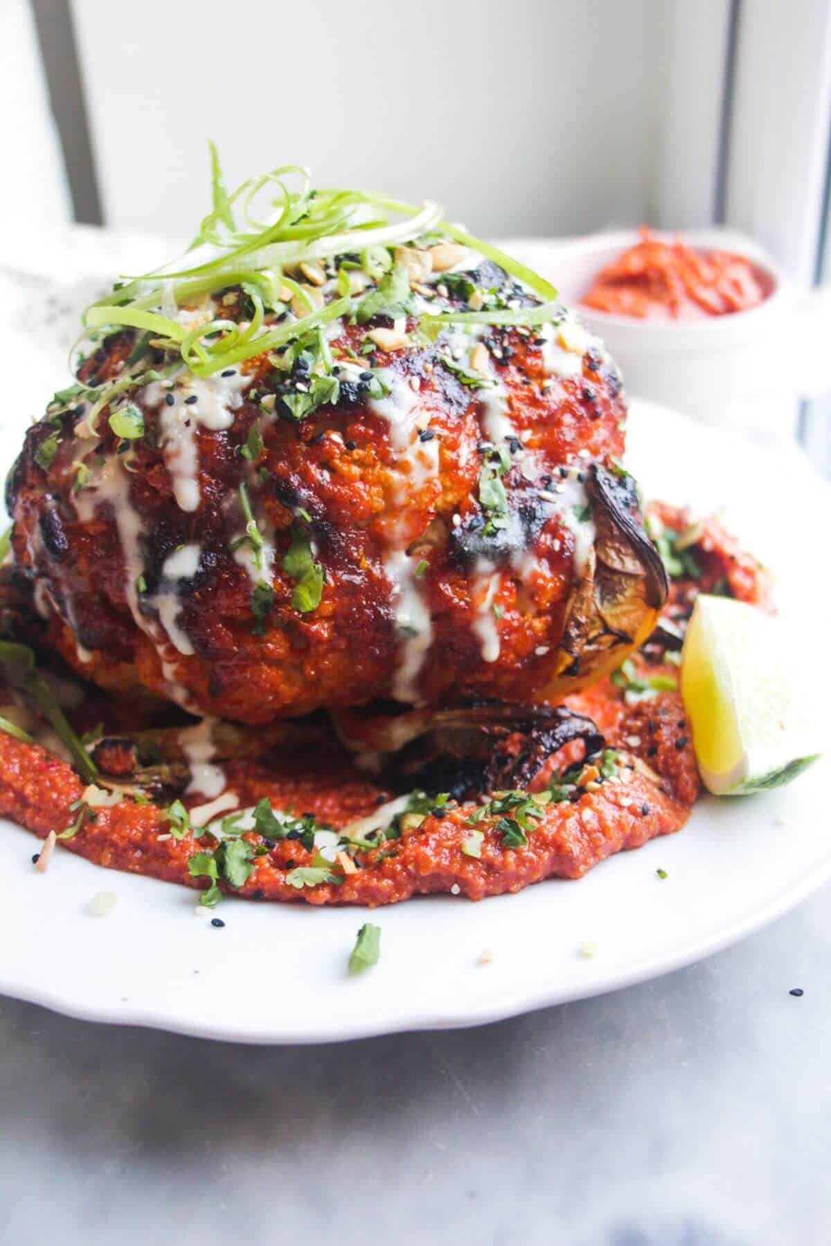 Whole roasted cauliflower topped with sesame seeds, coriander, spring onions and tahini.