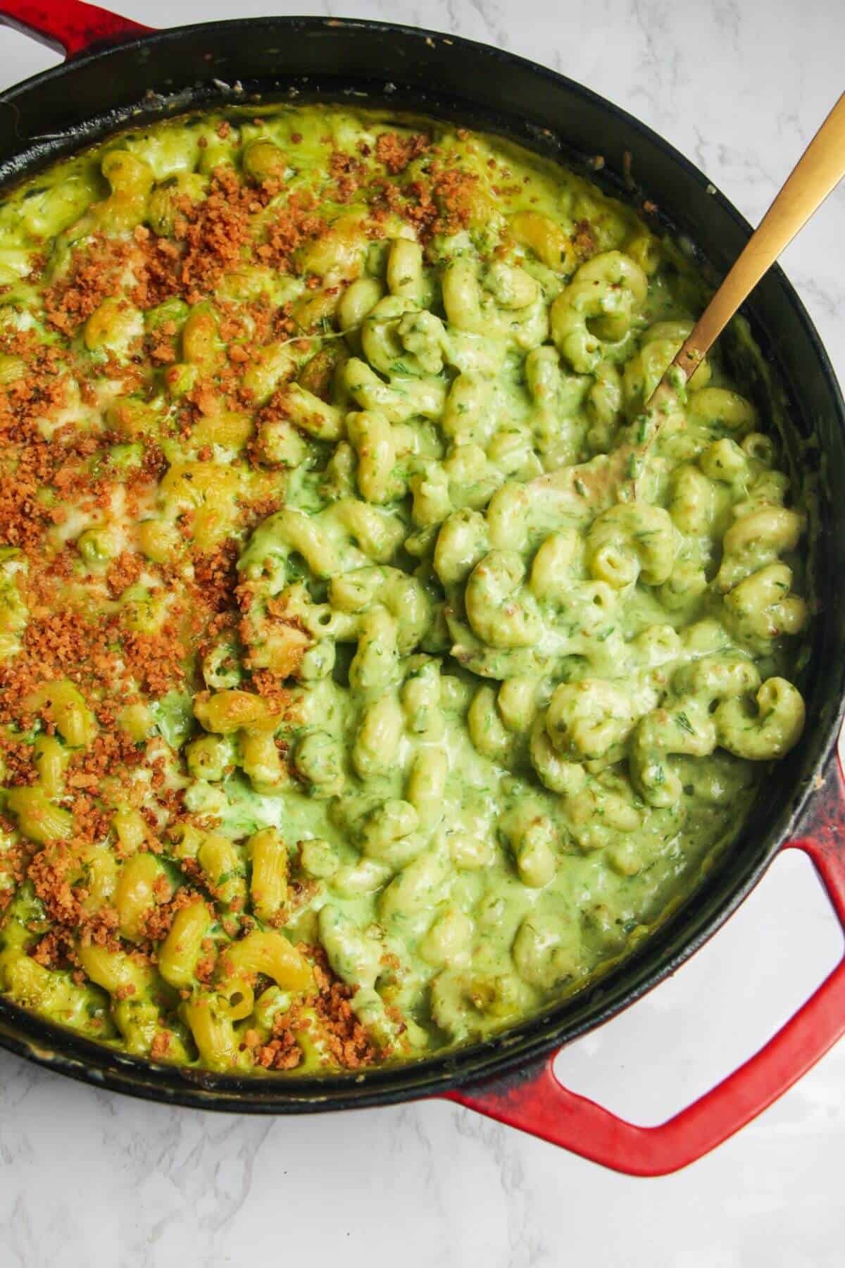 Gold spoon inside gooey green wild garlic mac and cheese.