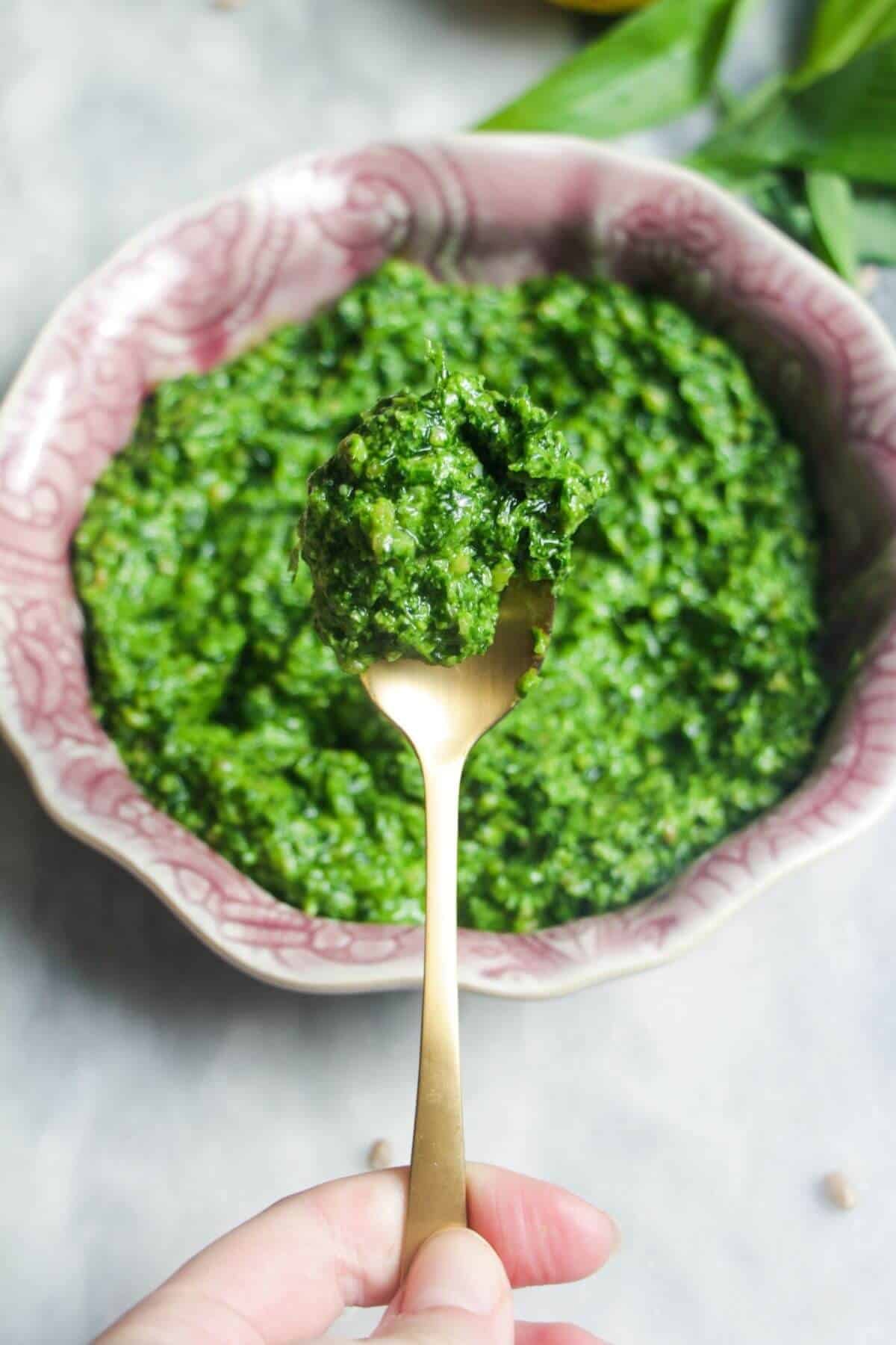 Close up of wild garlic pesto on a small gold spoon.