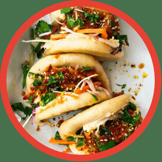 Three chicken bao buns stuffed with colourful vegetables.