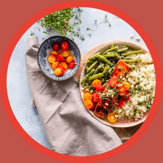 Two bowls of colourful salad on a blue background.