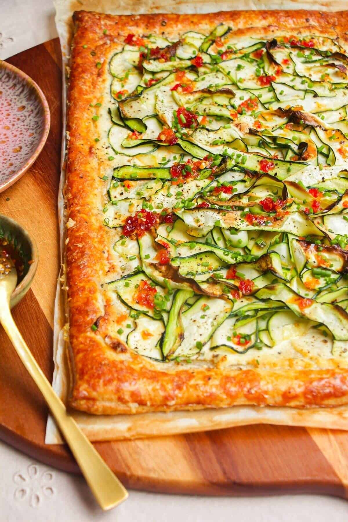 Zucchini and boursin tart on wooden board.