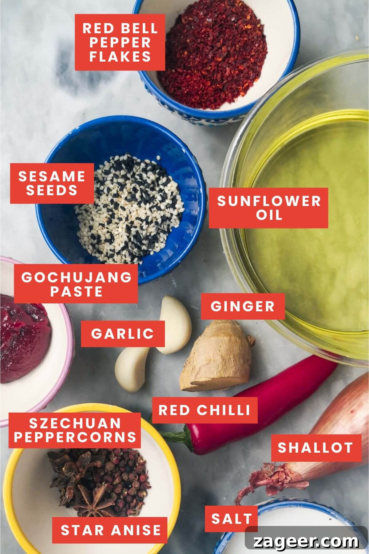 Key ingredients for homemade chili oil laid out on a grey marble background.