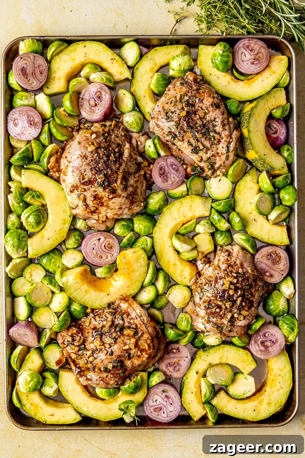 One-Pan Fall Chicken Feast 11 Step 4: Arranging chicken thighs skin-side up among the vegetables on the sheet pan