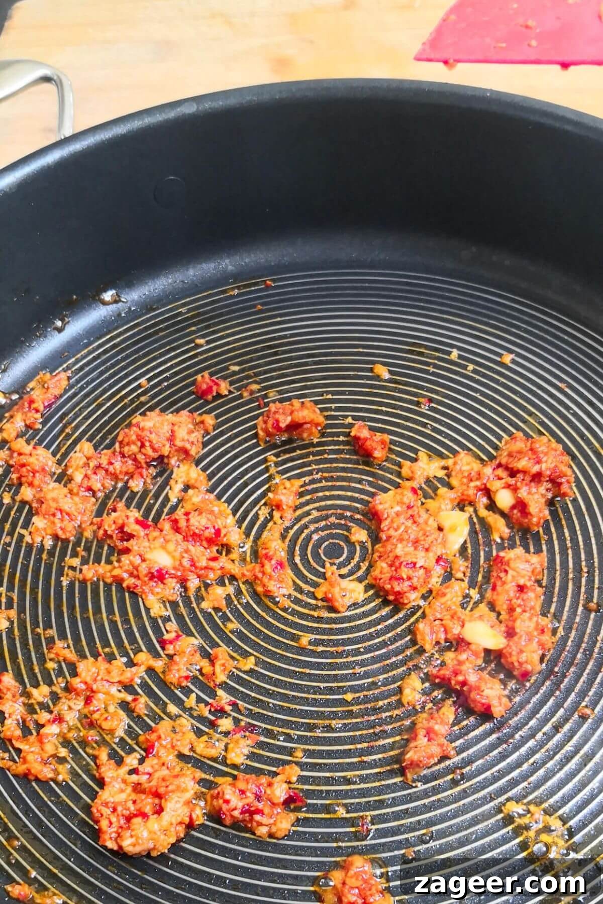 Quick Spicy Nduja Pasta with Creamy Burrata 4 Nduja frying in a large black pan, breaking down into the olive oil.