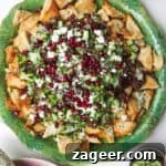 Middle Eastern style nachos on a green plate, with cucumber on the side.