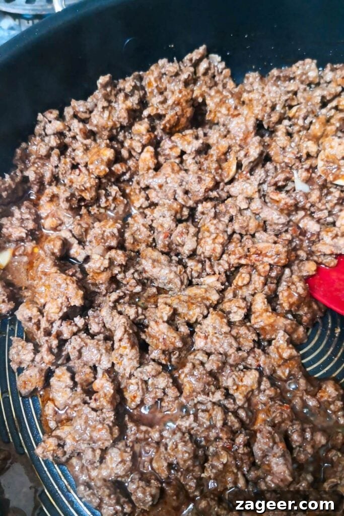 Sticky Beef Fatteh Middle Eastern Layered Nachos 5 Deliciously cooked sticky beef mince, glistening with pomegranate molasses, ready to be served from a large pan.