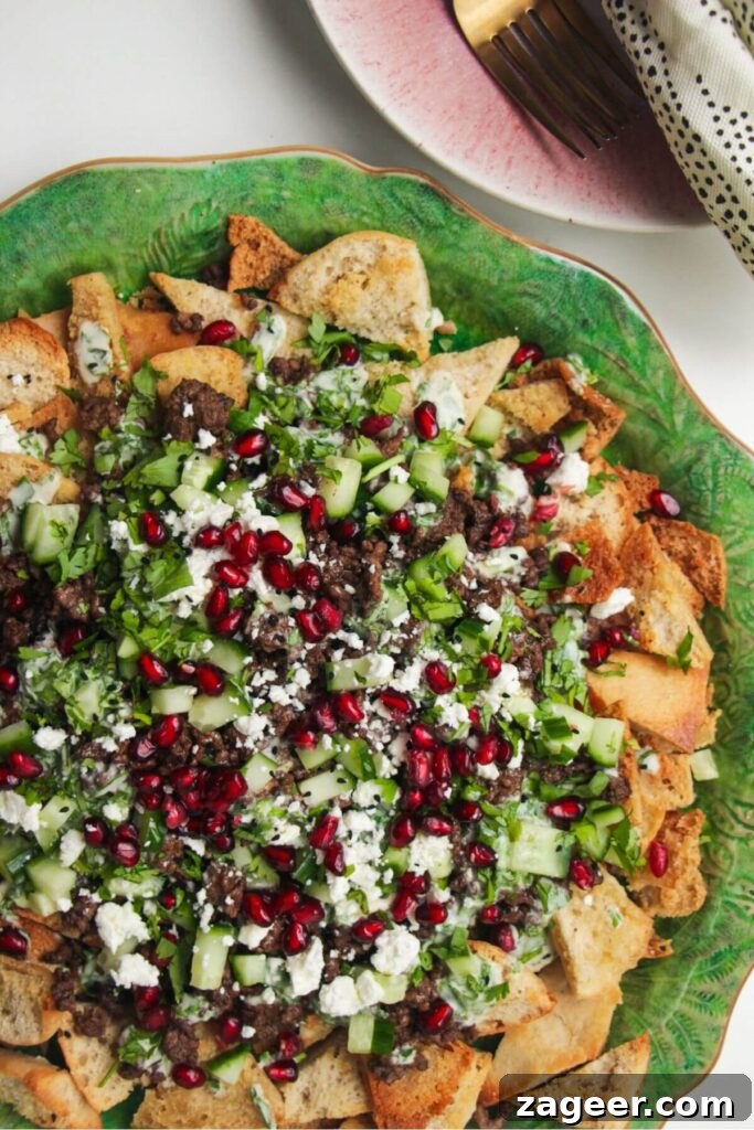 Sticky Beef Fatteh Middle Eastern Layered Nachos 6 The fully assembled Middle Eastern style nachos on a large platter, showcasing layers of beef, toppings, and sauce, ready for serving.