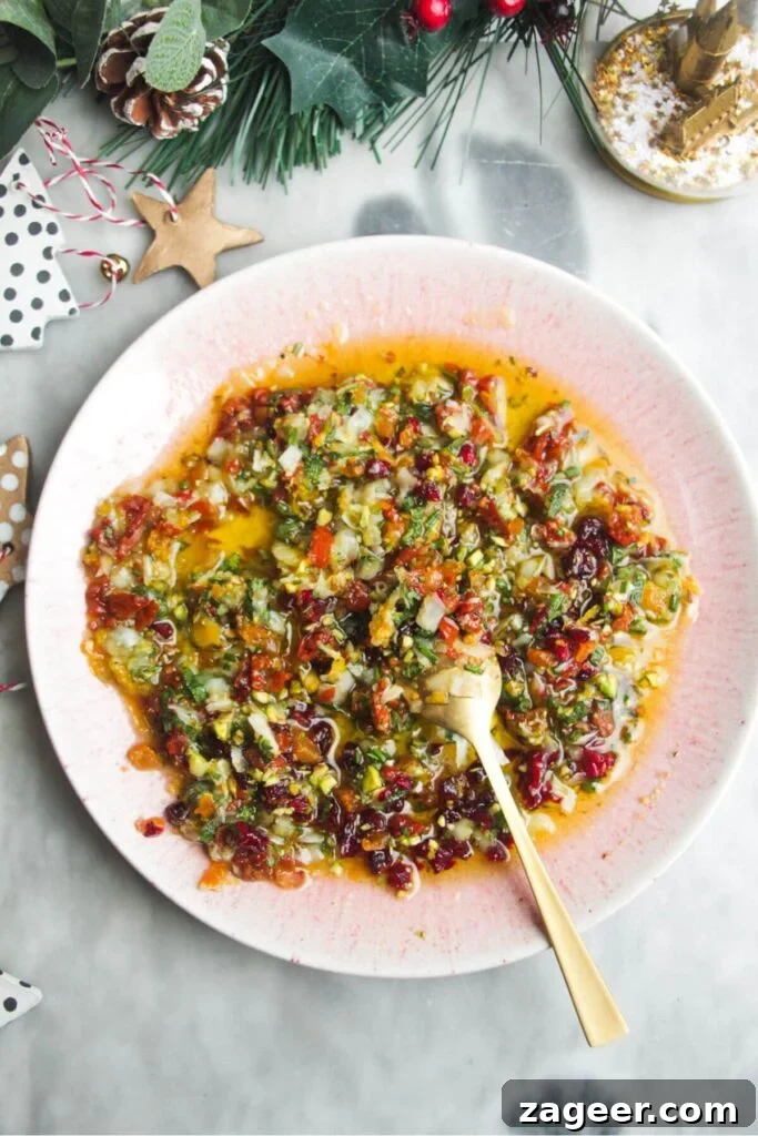 Gourmet Holiday Bread Dipping Blend 4 Festive dipping oil in a small pink plate on a grey surface, ready for serving.