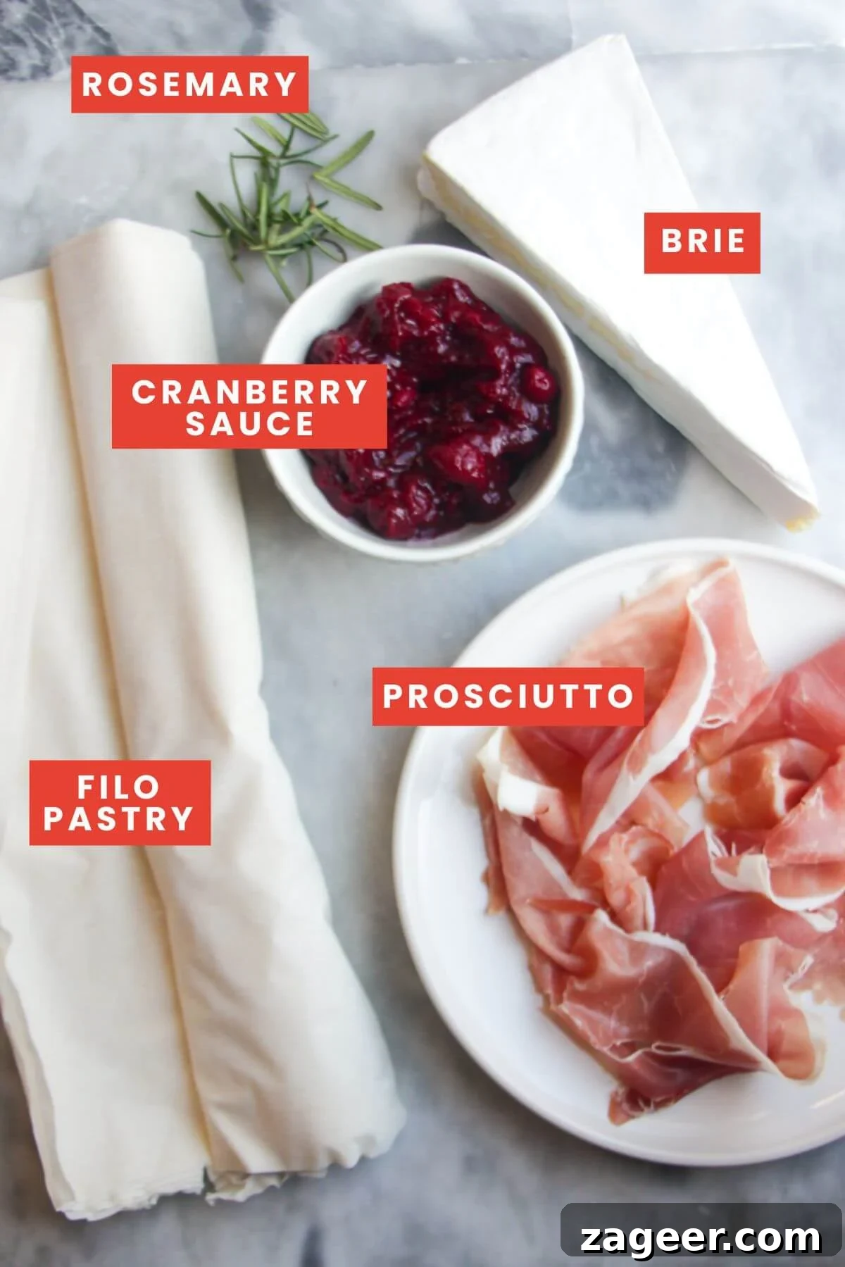 Effortless Brie, Cranberry, and Prosciutto Filo Parcels 3 Five core ingredients for Brie, Cranberry, and Prosciutto Filo Bites laid out on a grey marble background, clearly labelled for easy reference.