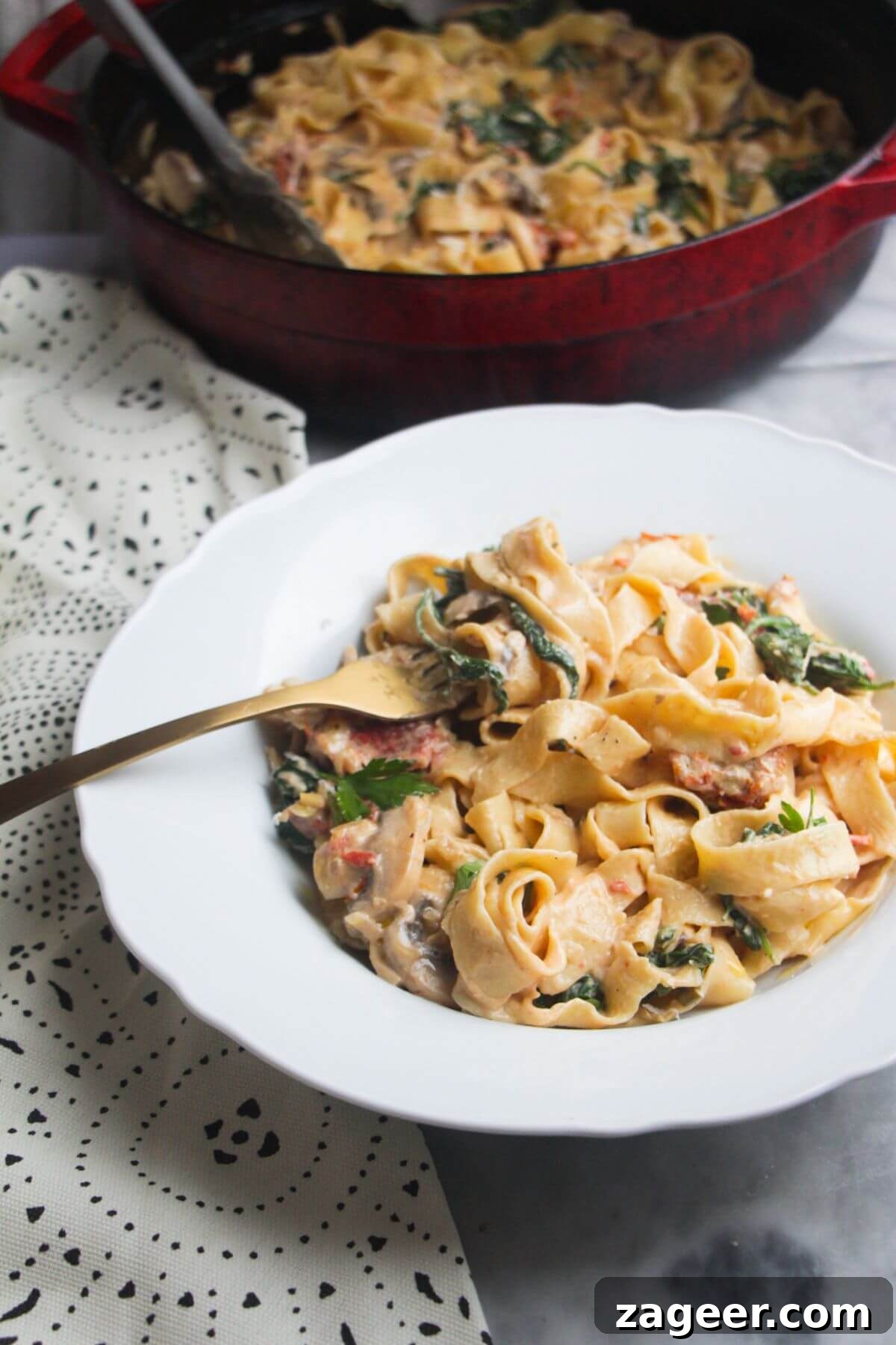 Creamy Miso Mushroom Fettuccine Alfredo 2 Close up of a bowl of creamy mushroom pasta, with a fork in it, highlighting the rich sauce and tender mushrooms.