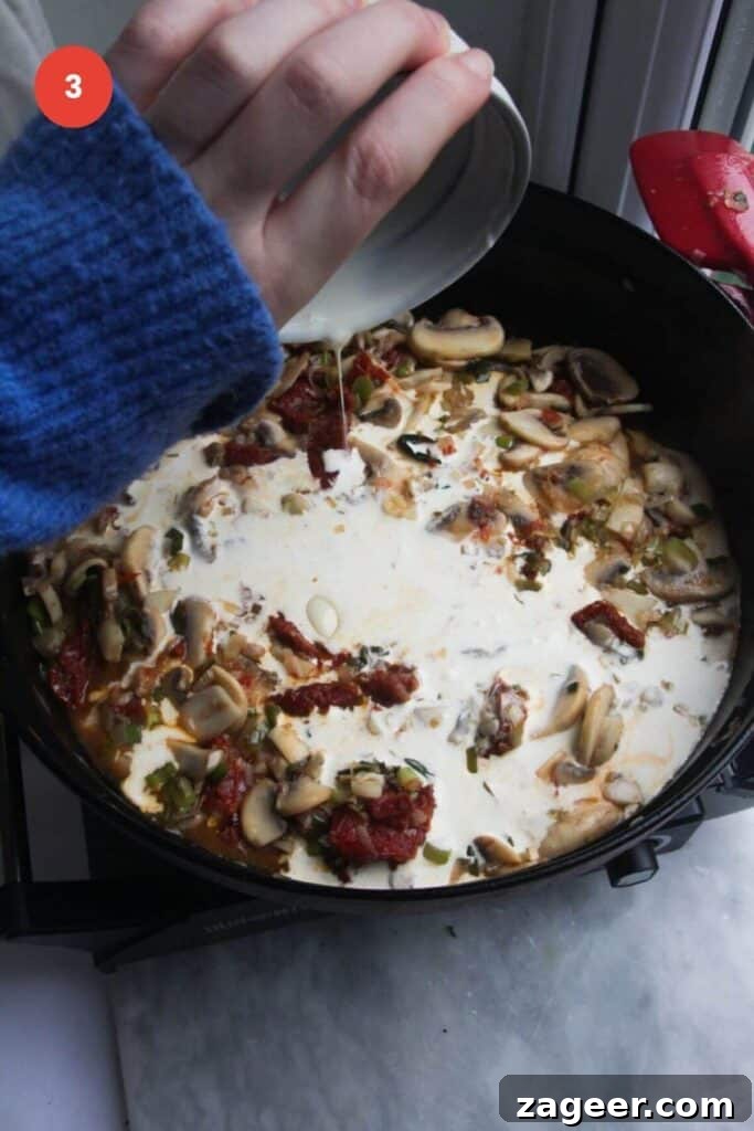 Creamy Miso Mushroom Fettuccine Alfredo 6 Pouring rich heavy cream into the pan with cooked mushrooms and sundried tomatoes, ready to form the Alfredo sauce.