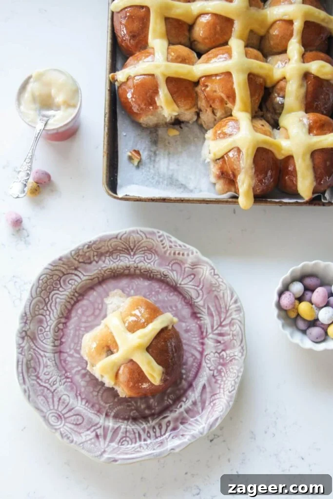 Easter Mini Egg Chocolate Hot Cross Buns 16 Mini egg hot cross bun on a small pink plate with more hot cross buns in the background.