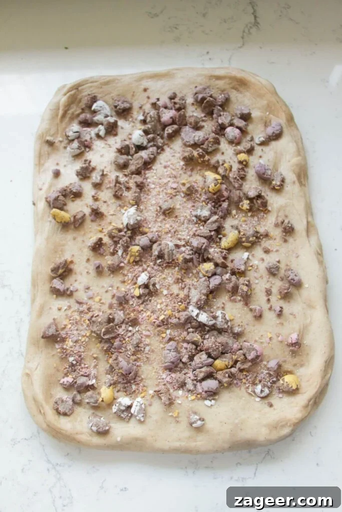 Easter Mini Egg Chocolate Hot Cross Buns 6 Crushed mini eggs scattered on top of hot cross bun dough stretched out into a large rectangle.