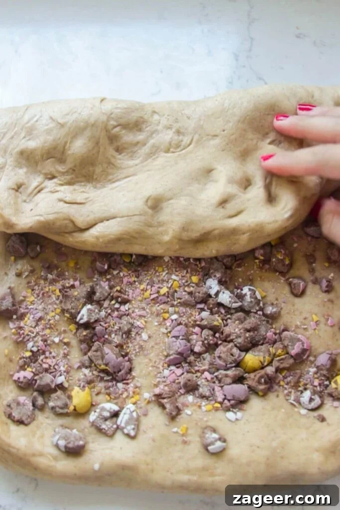 Easter Mini Egg Chocolate Hot Cross Buns 7 Hand folding mini egg studded dough over itself.