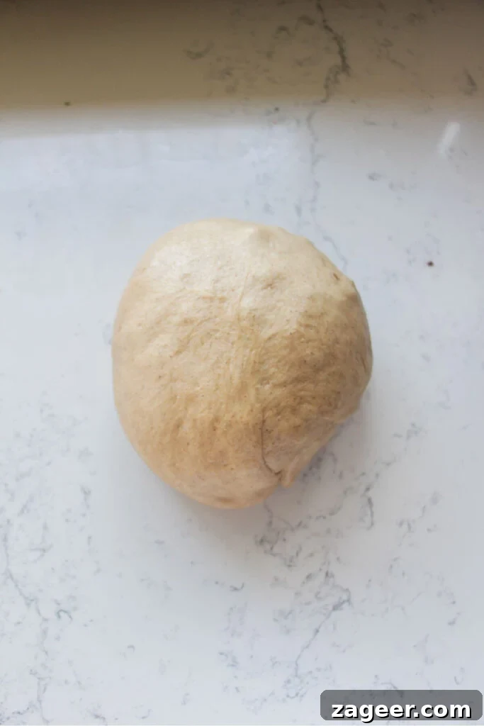 Easter Mini Egg Chocolate Hot Cross Buns 9 Mini egg hot cross bun dough in a large ball on a white marble background.