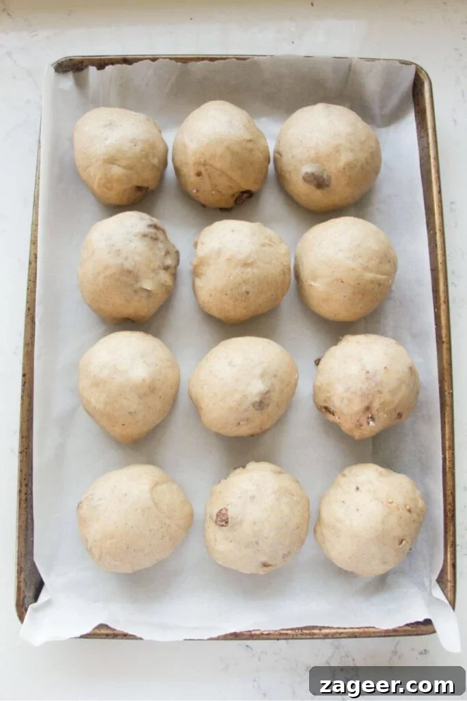 Easter Mini Egg Chocolate Hot Cross Buns 10 12 mini egg hot cross bun dough balls on a lined oven tray.