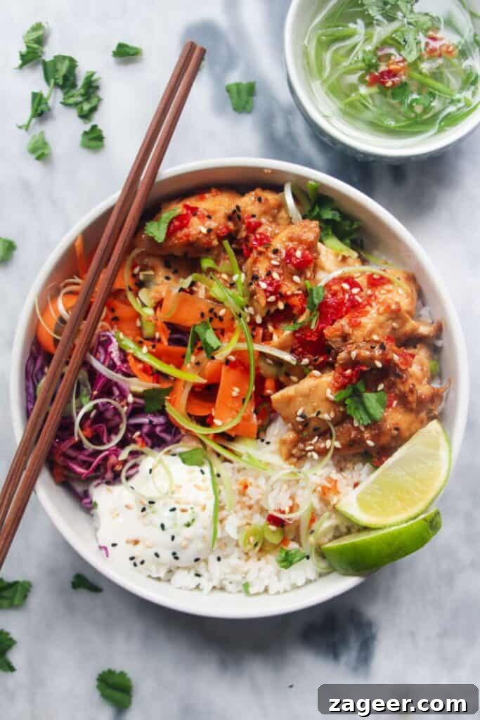 Speedy Chicken Rogan Josh 11 A vibrant grilled chicken poke bowl brimming with fresh vegetables, rice, and succulent grilled chicken, presented on a sleek grey marble background.