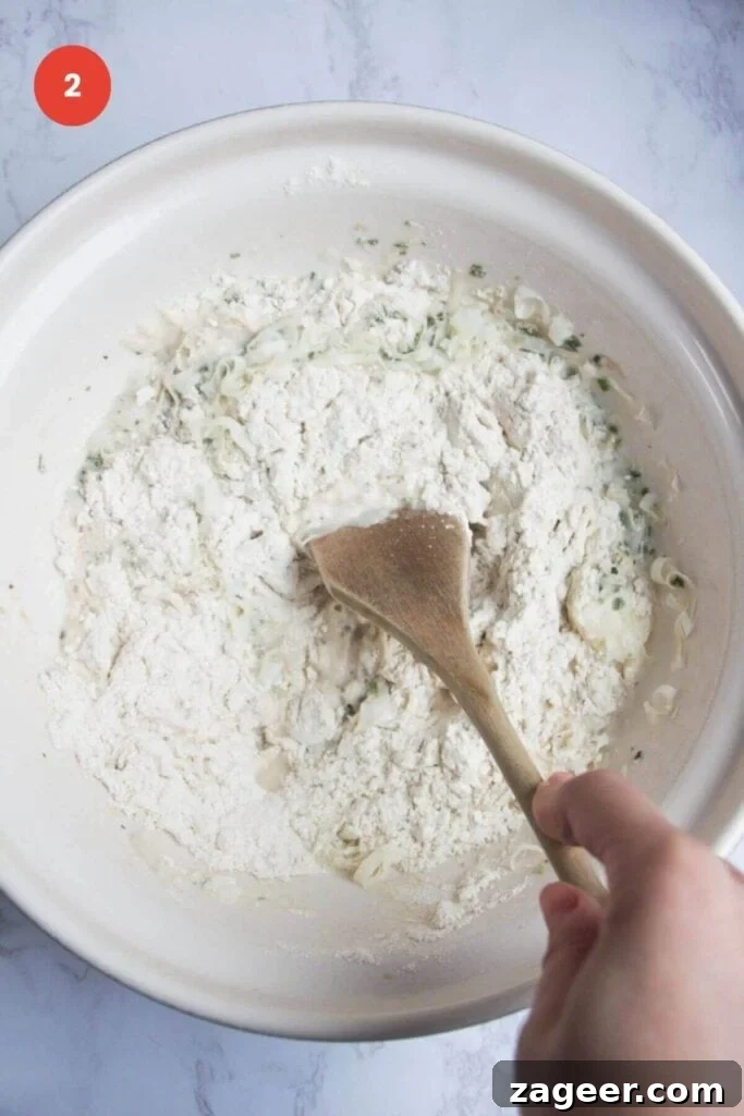 Artisan Style Rosemary Parmesan Bread Done Easy 5 Mixing ingredients for rosemary parmesan bread in bowl.