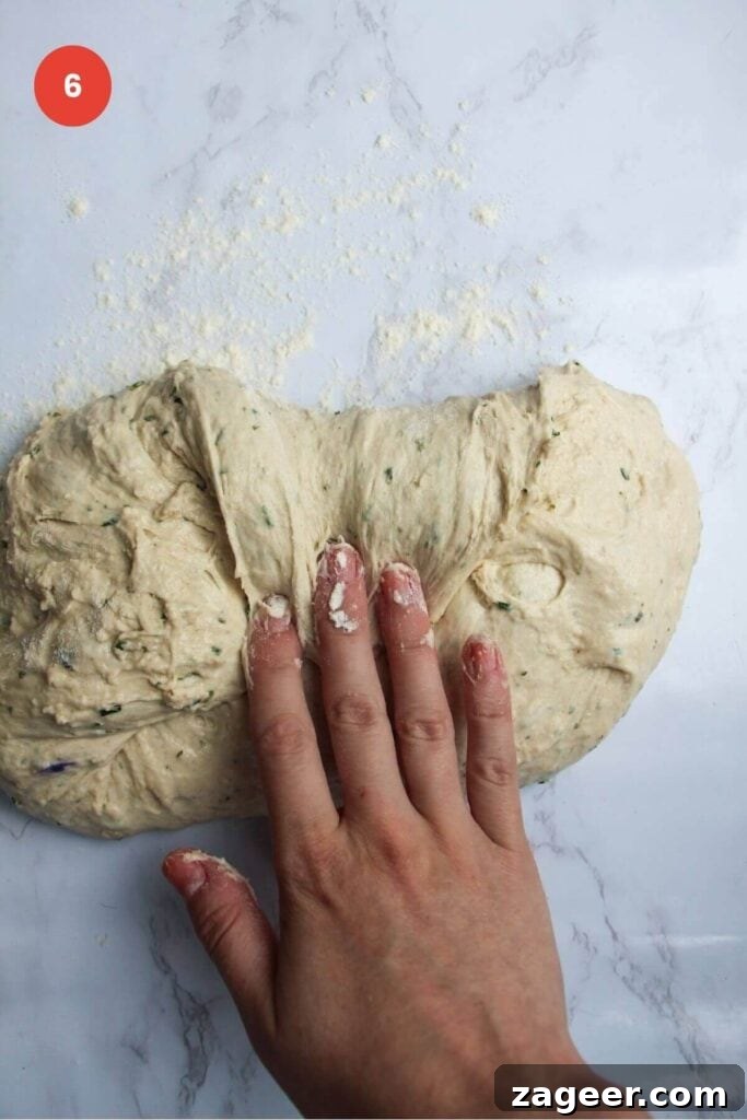 Artisan Style Rosemary Parmesan Bread Done Easy 9 Hand folding bread dough over itself.